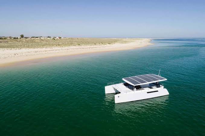 A cove anchorage over a pale sandbar, guests swimming